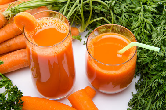 Composition with two glasses of carrot juice and carrots
