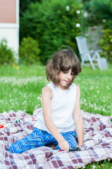 Cute happy little girl playing with toys in the garden on a summ