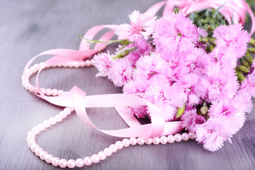 Beautiful bouquet with ribbon on wooden background