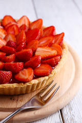 Strawberry tart on color wooden background