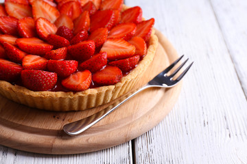 Strawberry tart on color wooden background