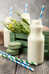 Milk in bottles with paper straws on table