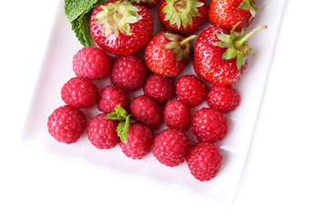 Forest berries on plate, isolated on white
