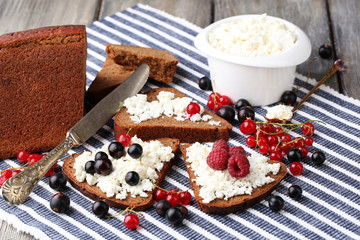Bread with cottage cheese and berries on napkin close-up