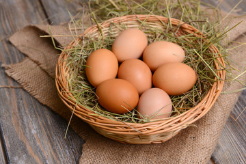 Eggs in wicker basket on table close-up