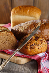 Composition of fresh baked bread, knife and kitchen towel,