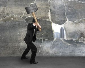 Man cracking old concrete wall