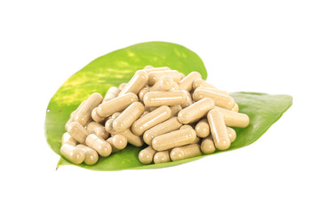 herb capsule on green leaf isolated ,white background