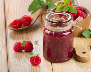 Glass jar of jam with fresh raspberries