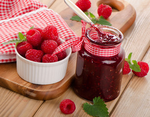Glass jar of jam with fresh raspberries