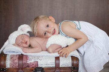 Adorable little baby boy, sleeping, his big sister cuddling him © Tomsickova