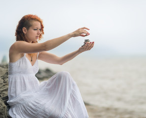 Fototapeta na wymiar Redhead woman holding zen stones in hand.