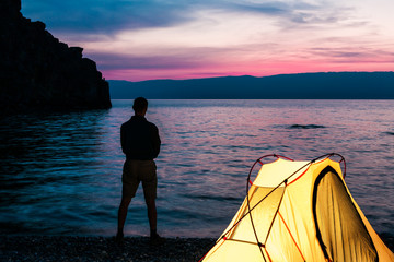 Silhouette of man near tent at the lake © tolstnev