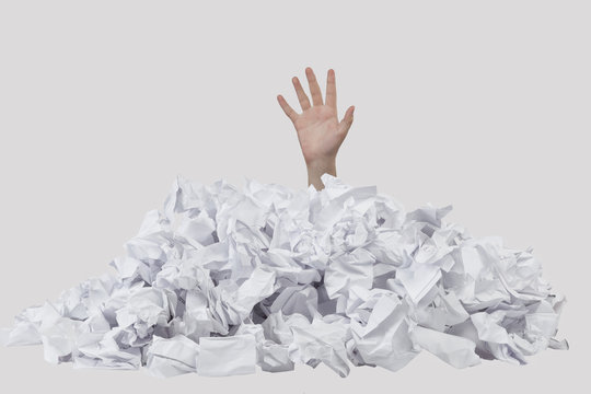 Hand sticking out of crumpled papers