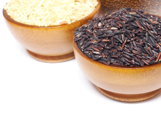 Grains of rice in wooden bowl isolated on white background