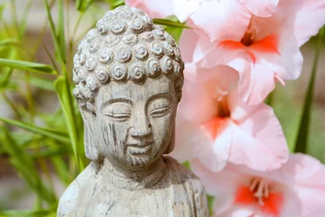 Fotobehang Boeddha in  bamboe tuin met bloemen © trinetuzun