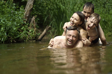 Beautiful family swims in the river