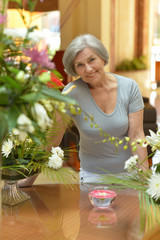 Senior woman standing near the table