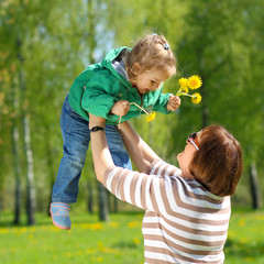 Grandmother and granddaughter playing on the meadow of ye