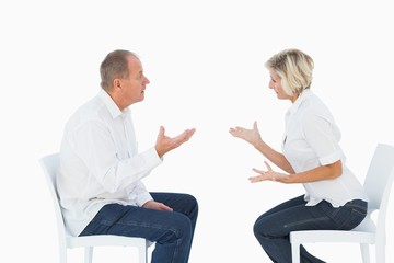 Fototapeta premium Older couple sitting in chairs arguing