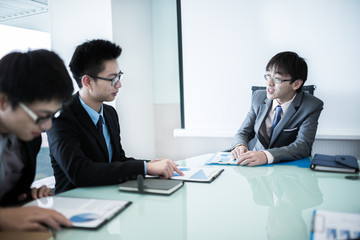 Young business people sitting in board room during meeting and d