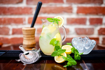 fresh, iced mint lemonade in a jug with sliced lemon, mint