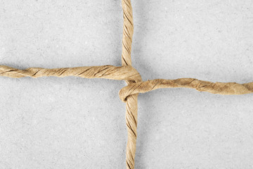 String tied in a bow on  packaging paper