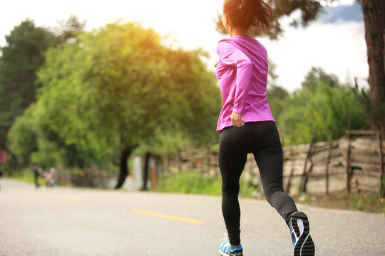 Young Woman Runner Athlete Running On Country Road