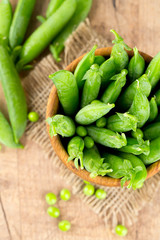 fresh pea pods in a wooden bowl