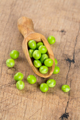 fresh pea pods in a wooden scoop