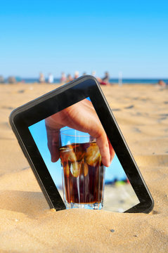 a tablet on the sand of a beach with a picture of a man with a g
