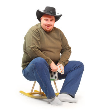 Overweight cowboy riding on a rocking horse.