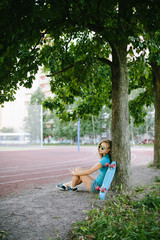 beautiful girl sitting near the skateboard