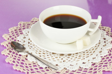 A cup of strong coffee on purple background