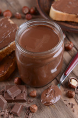 Sweet chocolate cream in jar on table close-up