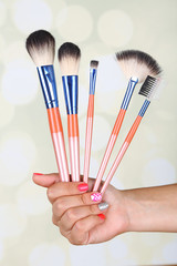 Female hand with stylish colorful nails holding brush,