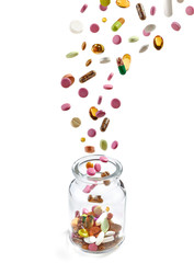 various medical pills falling into glass jar