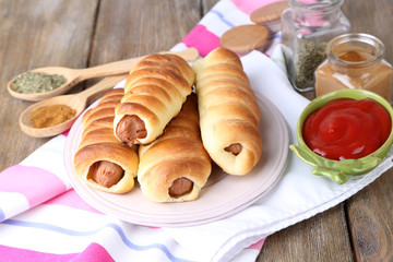 Baked sausage rolls on plate on table close-up