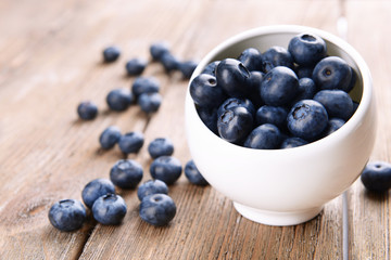 Delicious blueberries in bowl on table close-up