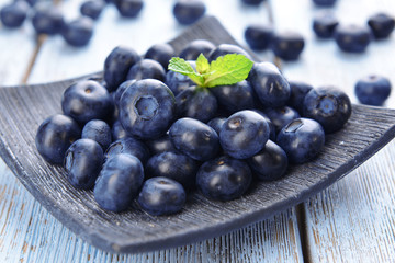 Delicious blueberries on plate on table close-up