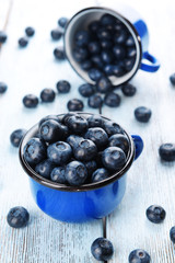 Delicious blueberries in cups on table close-up