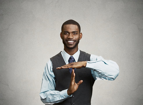 Smiling executive man giving time out gesture with hands