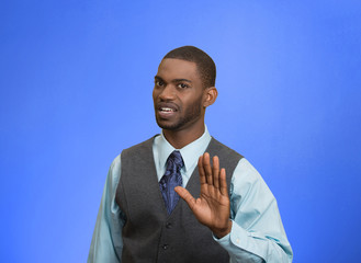 Angry executive gesturing with hands to stop, blue background 