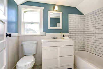 Aqua bathroom with white tile wall trim.
