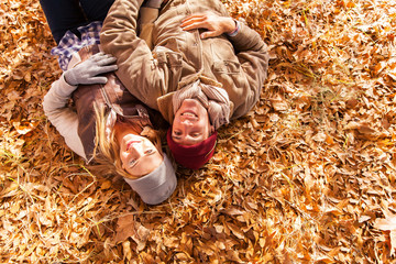 young couple lying on autumn leaves