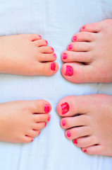 Fototapeta na wymiar Mother and child paint their feet with nail polish