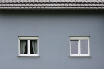 Graue Fassade eines modernen Wohnhauses mit zwei Fenstern