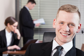 Smiling businessman and his co-workers