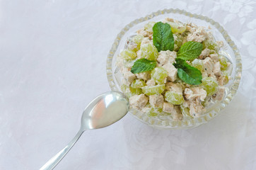 meat and vegetable salad in glass bowl with a spoon