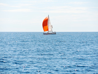 yacht with red sail in blue Adriatic sea